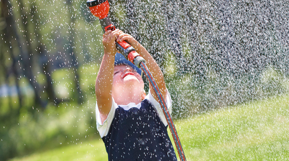 Bild på pojke som sprutar vatten med en vattenslag